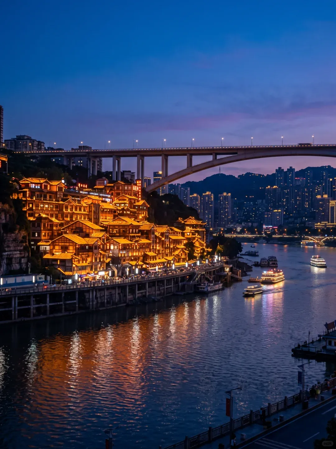 Hongyadong complex in Chongqing at night — multi-level traditional architecture illuminated along the Jialing River, a stunning contrast to Chengdu's low-rise skyline